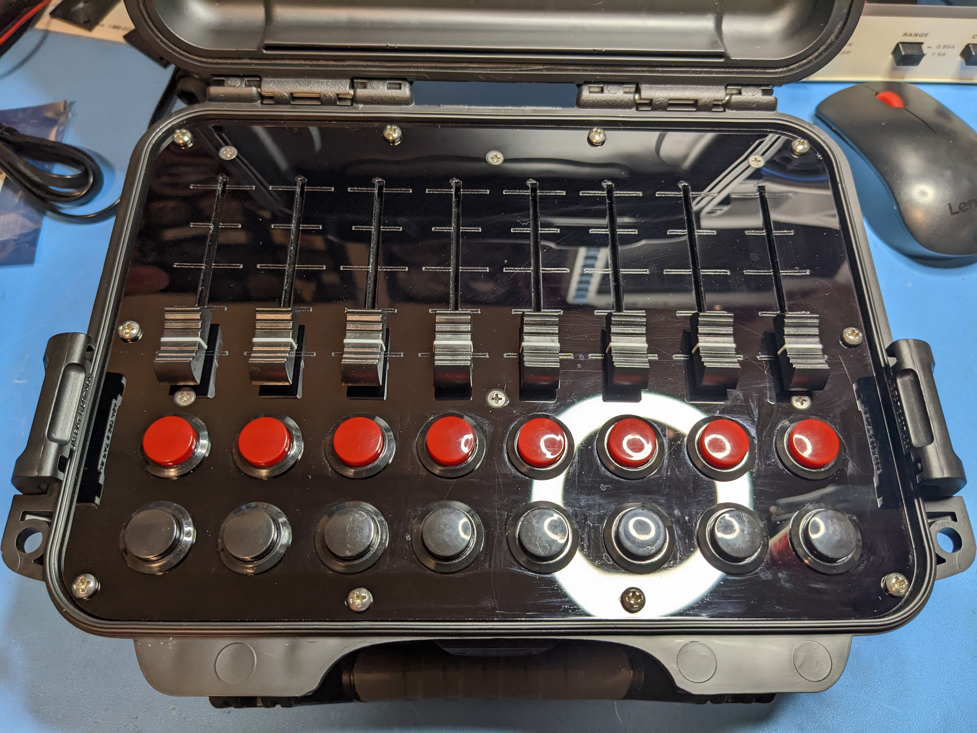 Photo of eight slider and 16 buttons on a black acrylic control panel